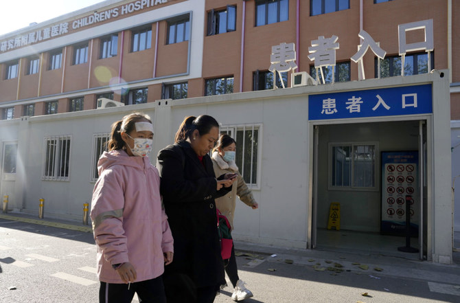 2023年11月24日金曜日、北京で「患者入口」の看板を掲げた小児病院の前を通り過ぎる人たち(AP通信)