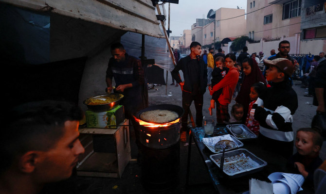 食料を買うために野営テントの外で待つ避難中のパレスチナ人たち。ガザ地区南部、ハーン・ユニス。（ロイター通信）