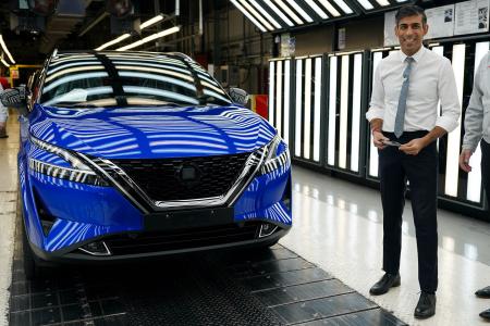 2023年11月24日、英国北東部サンダーランドにある日産の工場を訪問し、生産ライン上の「キャシュカイ」を見るイギリスのリシ・スナク首相。日産は、売れ筋の2車種のEVモデルをこの工場で生産すると発表した。(AFP)