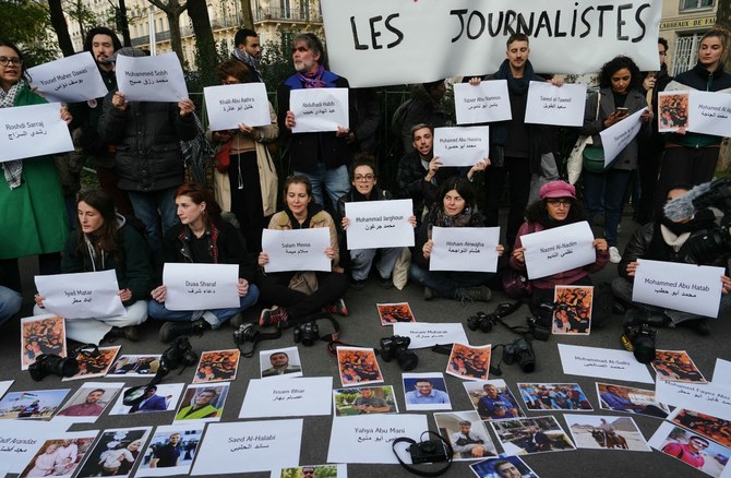 10月7日以降、ガザで殺害されたジャーナリストの名前と写真を掲げるデモ参加者。2023年11月11日。（AFP）