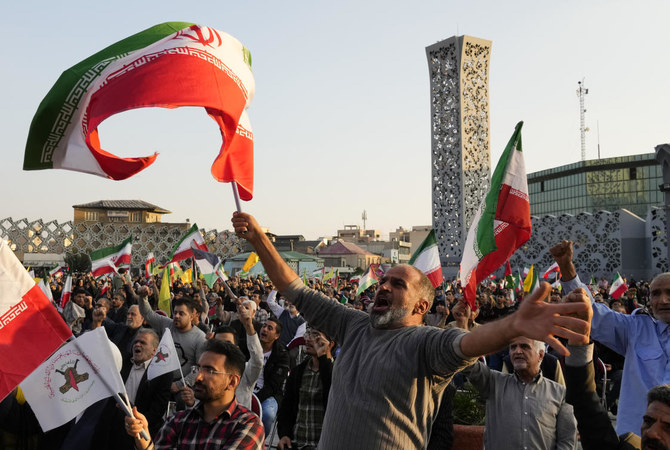 中心街の広場で開かれた親パレスチナ集会でイラン国旗とパレスチナの旗を振るイランのデモ隊。イランのテヘラン。(AP)