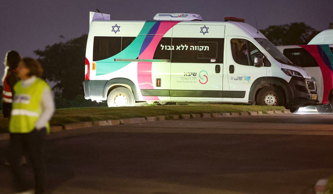 2023年11月26日、ハマスがガザ地区から解放した人質の到着に備え、ラマト・ガンのシェバ医療センター近くで準備する医療スタッフたち。救急車の近くではイスラエルの治安部隊が待機する。（AFP）