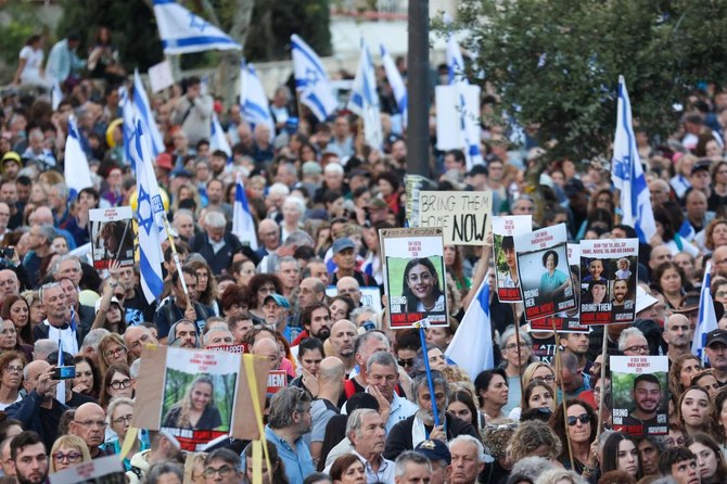 2023年11月18日、エルサレムの首相官邸前で人質解放を求めて抗議するイスラエルの人々。10月7日のイスラエル南部での武装組織ハマスによる奇襲攻撃以降、ガザ地区で拘束されている人質の写真、イスラエル国旗、プラカードを掲げている。(AFP)
