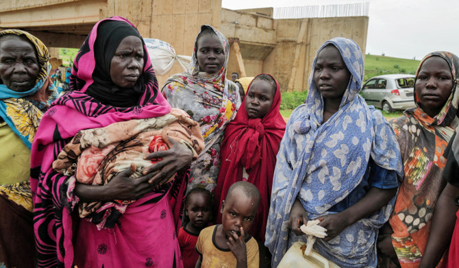 2023年8月4日、チャドのアドレでスーダンとチャドの国境を越えて立つスーダン人女性たち。この女性たちはスーダンのダルフール地域にあるムルネイでの紛争から逃れてきた。（ロイター通信）