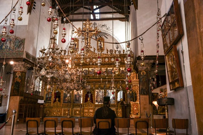 ベツレヘムのイエス・キリスト生誕地の上に建てられたとされる降誕教会に座る聖職者。（AFP）