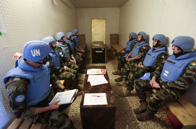 壕の中で一緒に座るアイルランドの平和維持軍兵士たち。2023年11月29日、レバノンとイスラエル国境そばのマルーン・アル・ラス村付近にある、アイルランドとポーランドのUNIFIL平和維持軍が駐留するキャンプ・シャムロックをロイターが訪問した際に撮影。（Reuters）