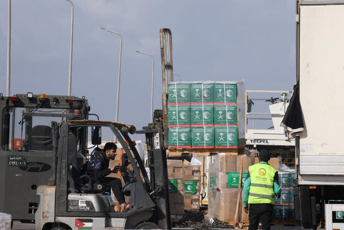 2023年11月27日、エジプトのエル・アリーシュ空港で、ハマスとイスラエルの一時休戦の間に、ラファの国境地帯を通ってガザ地区へ届けられる予定の人道援助物資の荷下ろしをする作業員たち。（ロイター）
