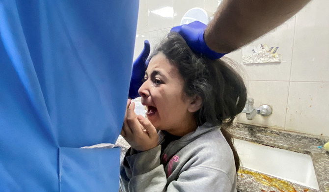 ハマスとイスラエルの一時停戦終了後、イスラエル軍の空爆で負傷したパレスチナ人の少女が、ガザ地区南部のハーンユーニスにあるナセル病院で介助を受けている。2023年12月1日。(ロイター）