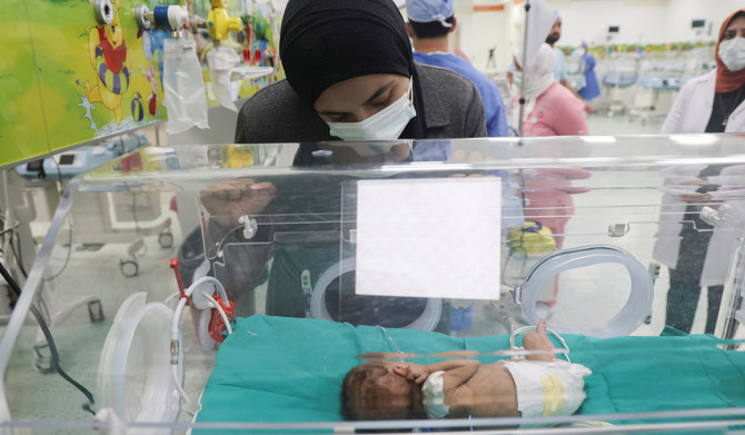 2023年12月6日、エジプト・カイロ東部の新行政首都（NAC）病院。イスラエルとパレスチナのイスラム主義組織ハマスの紛争が続く中、ガザから避難してきた23歳のパレスチナ人女性シマー・アブ・ハテルさんが、治療を受けている生後38日の未熟児の娘、キンダちゃんを見守っている。（ロイター）