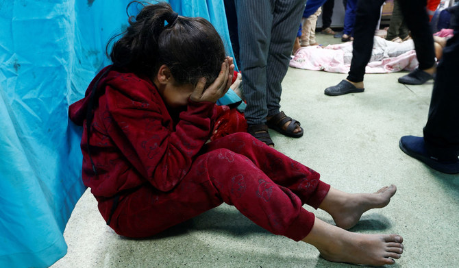 2023年12月8日、イスラエルとパレスチナのイスラム主義組織ハマスとの戦闘が続く、ガザ地区南部のハーン・ユーニス。イスラエル軍の空爆で負傷し、ナセル病院の床に座るパレスチナ人の子供。(ロイター通信)