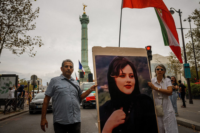 イランのマフサ・アミニ氏の一周忌に、デモ参加者らが故アミニ氏の肖像画を掲げ、パリのバスティーユ広場前でイラン政権に対する抗議活動を行っている。（AFP通信）