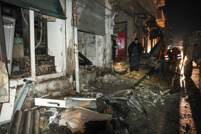 2023年12月9日のシリア軍によるイドリブの爆撃後、作業員が瓦礫を片付けている。（AFP）