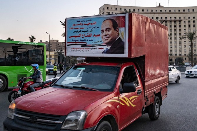 2023年12月1日、カイロ中心部のタハリール広場の主要な環状交差点で、現職のエジプト大統領で無所属の大統領候補であるアブドゥルファッターハ・エルシーシ氏を支持する民間小売店による選挙看板を掲げた軽トラック。（AFP）