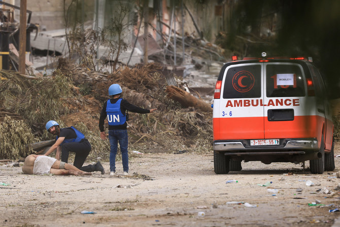 ガザ市から避難する際にイスラエル軍に撃たれたという、負傷したパレスチナ人に近づく国連スタッフ。（File/AFP）