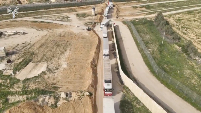 イスラエル、ガザ、エジプトの国境にあるケレム・シャローム検問所で検査を受けるために列をなす人道支援トラック。X（旧Twitter）に投稿された動画の静止画像。(COGAT video/Handout via REUTERS）