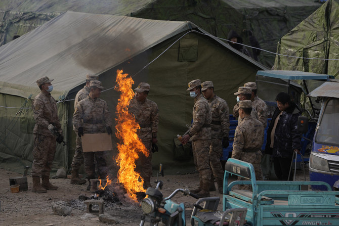 2023年12月20日、中国北西部の甘粛省大河家鎮で発生した地震の後、仮設避難所で焚き火のそばに集まる人民解放軍の兵士たち。（AP）