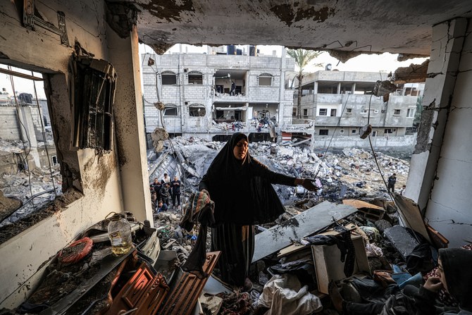 12月19日、ガザ地区南部のラファで、イスラエルの砲撃で一夜にして死亡したパレスチナ人ジャーナリスト、アデル・ゾロブの破壊された建物を検査する女性（AFP）。