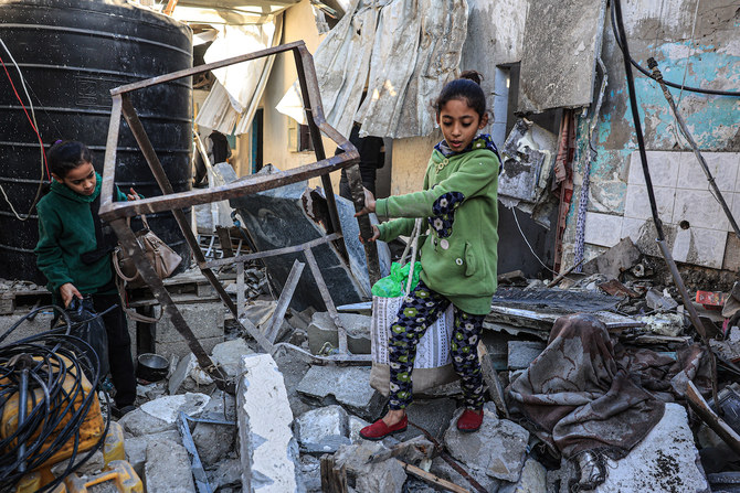 12月26日、ガザ地区南部ラファで、イスラエルの爆撃後、ビルのがれきを捜索するパレスチナ人少女ら（AFP）