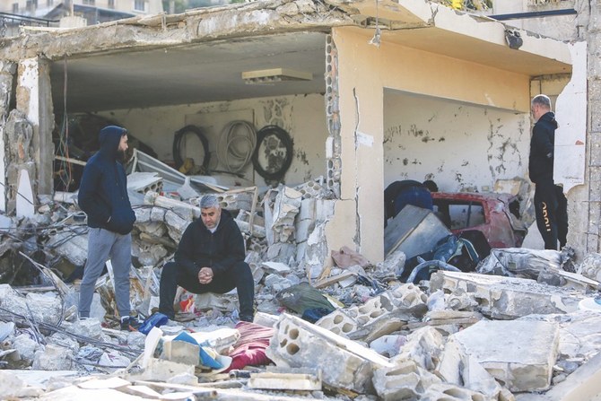 レバノン南部のビント・ジュベイルで建物の瓦礫を調べる男性たち。（AFP）