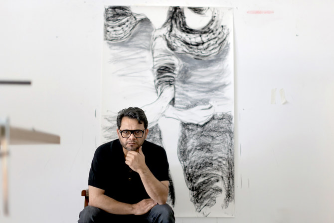 パレスチナ人アーティストのハゼム・ハーブ。11月に『Dystopia Is Not A Noun（ディストピアは名詞ではない）』シリーズのために制作した作品の前で。（提供）