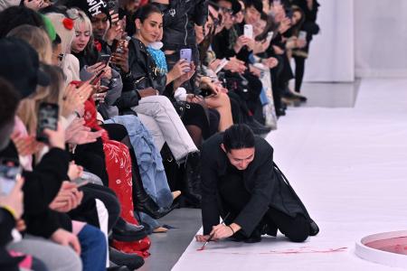 2024年1月24日、パリで開催された2024年春夏ウィメンズオートクチュールファッションウィークで、観客に感謝を示しながらステージを絵の具で彩る日本人ファッションデザイナーのユイマ・ナカザト。（AFP）
