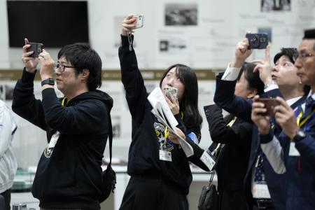 小型月着陸実証機(SLIM)のピンポイント月面着陸のライブ配信を鑑賞する宇宙航空研究開発機構(JAXA)職員。ライブ配信は東京近郊の相模原にあるJAXA相模原キャンパスにて、2024年1月20日に行われた。(AP)