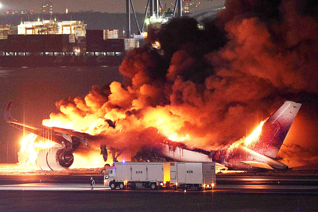 時事通信提供の写真は、羽田空港の滑走路で炎上する日航機（2024年1月2日撮影）。- 1月2日、東京の羽田空港の滑走路で、海上保安庁の航空機と衝突したとみられる日航機が炎上していると、メディアが報じた。(時事通信／AFP＝時事） 