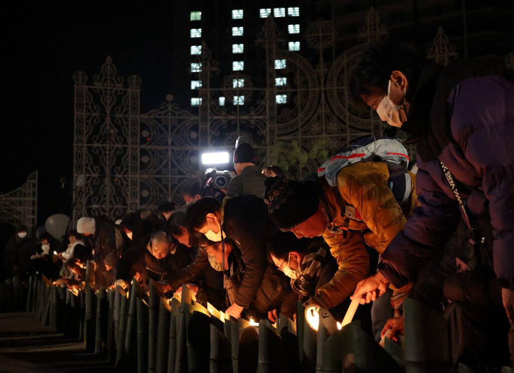 能登半島地震の被災地と「共に助け合おう」という思いと、世代を超えて阪神大震災を語り継ぐとの意志を込め、「１９９５　ともに　１．１７」の形に灯籠を並べて火をともし、地震発生時刻の午前５時４６分に黙とうした。(AFP)