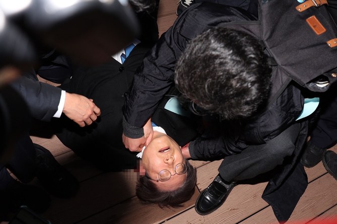 釜山で襲撃され、手当てを受ける韓国の野党党首イ・ジェミョン氏　(AFP＝時事）