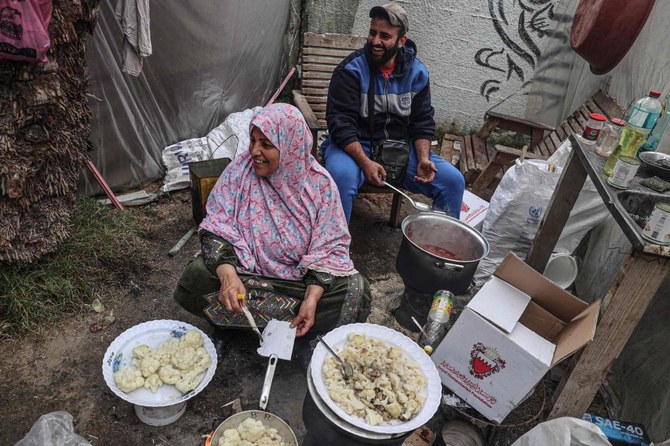 イスラエルと武装組織ハマスの紛争が続く中、避難先のガザ地区南部ラファの動物園内の避難所で食事を作る避難民たち。2024年1月2日。（AFP）