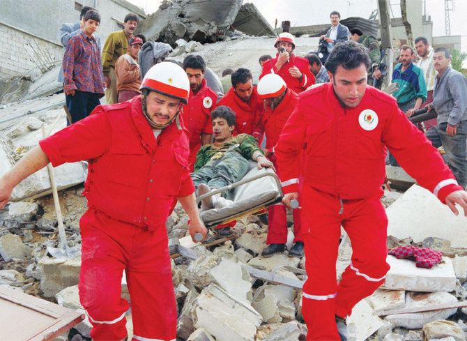 レバノン南部のアッパー・ナバティエ村で11人家族の母親と8人の子供たちを死亡させたイスラエル軍機による爆撃の後、負傷した年若い生存者を担架で運び出す救助隊員たち。1996年4月18日。（AFP / 資料画像）