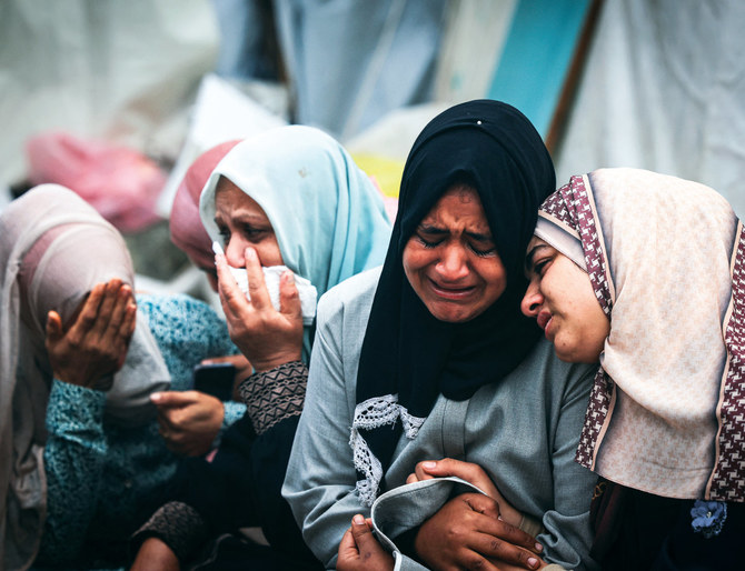 2023年12月24日、ガザ地区中央部のアル・マガジ難民キャンプで、イスラエルによる夜間の空爆で死亡した親族を悼むパレスチナ人女性たち。イスラエルは現在、ガザのパレスチナ市民センターへの無差別攻撃をめぐり、国連の最高司法機関でジェノサイド（大量虐殺）の訴えに直面している。(AFP）