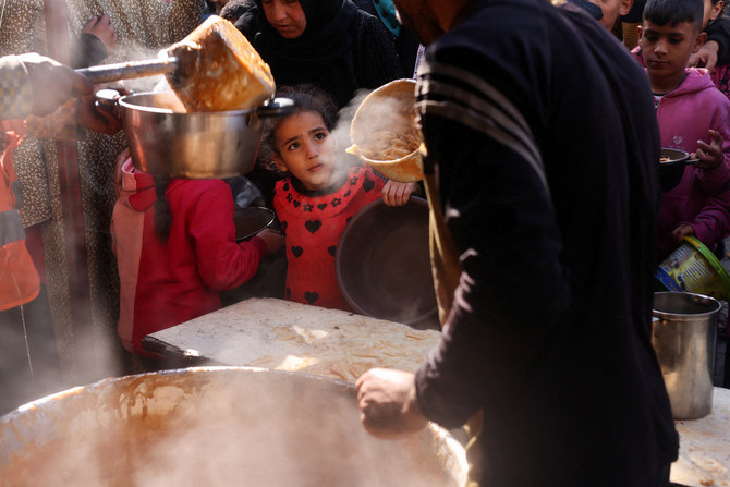 ガザ地区南部のラファで、食料が不足するなか食べ物の受け取りを待つパレスチナ人たち。（ロイター通信）