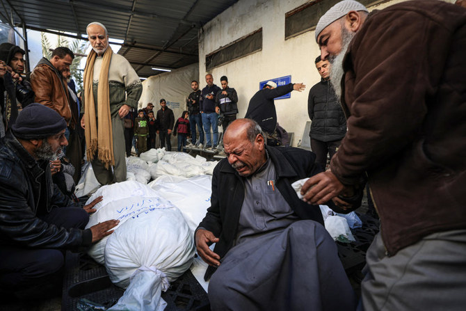 イスラエルによる爆撃の犠牲となった遺体のそばで嘆き悲しむパレスチナ人。ガザ地区南部のラファにて、2024年1月18日撮影。（AFP）