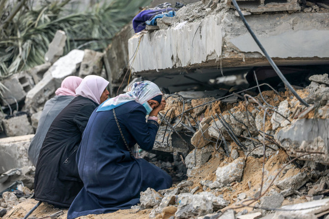 2023年12月21日、ガザ地区南部のラファで、イスラエルの爆撃のあとに瓦礫の下に埋まった親類を追悼するパレスチナ人女性たち。（AFP）