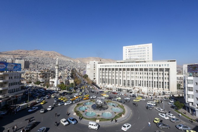 写真はシリアの首都ダマスカスにあるサバ・バーラート広場の全景。右にはシリア中央銀行の建物、後ろにはカシオン山が見える。2024年1月9日撮影。（AFP通信）