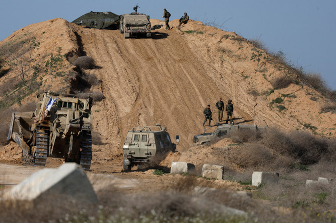 イスラエルとパレスチナのイスラム主義組織ハマスとの紛争が続く中、ガザとの国境付近で軍用車両を操縦するイスラエル軍兵士。（ロイター）