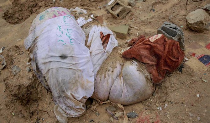 2024年1月11日、ガザ市東部アル・トゥファ地区にある仮設墓地で、遺体を包んだ布が泥にまみれて置かれている。その一部は、イスラエル軍がブルドーザーで掘り起こしたものと伝えられている。（AFP）