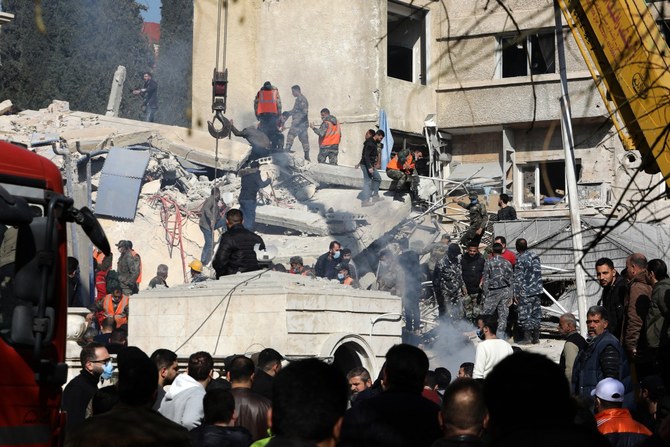 2024年1月20日、ダマスカスでイスラエルの空爆により破壊された建物の瓦礫を捜索する警備員と救急隊員の様子。（AFP）