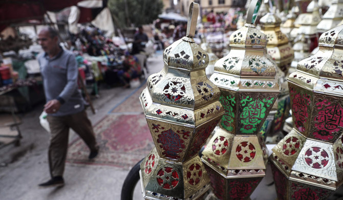 2020年4月17日、イスラム教の聖月ラマダーンを前に、カイロのサイーダ・ザイナブ地区で展示された、アラビア語で「ファヌス」と呼ばれる伝統的なランタンの前を歩くエジプト人男性。(AFP)