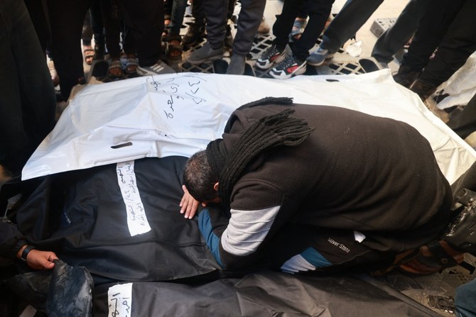 ラファのナジャール病院で、イスラエル軍の砲撃で殺害された親族の覆いに包まれた遺体を前に、合葬を控えてその死を悼むパレスチナ人。（AFP）