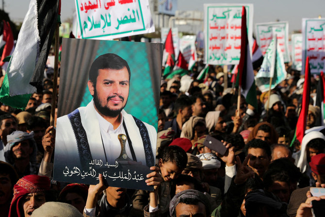 米英軍によるフーシ派拠点の空爆に抗議するフーシ派支持者集会で、フーシ派指導者アブドルマリク・アル・フーシ氏の顔写真のプラカードを掲げるデモ参加者。サナア、2024年1月12日。（Reuters）