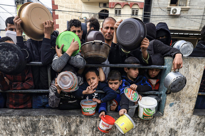 ガザ地区南部のラファにある難民キャンプで、食料の提供を待つパレスチナ人。（File/AFP）