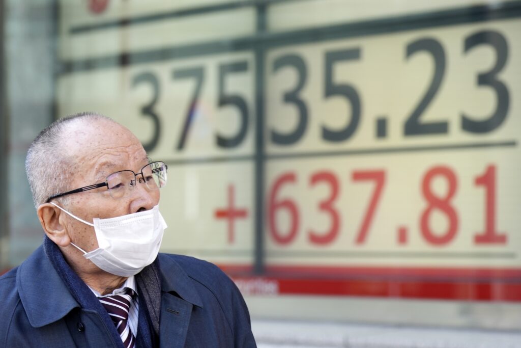 2024年2月13日火曜日、東京の証券会社で、日本の日経平均株価を表示する電光掲示板の前を歩く人。米国のインフレ率に関する最新の指標を見極めようとする投資家の動きから、火曜日のアジア株はほぼ上昇した。(AP写真/星子悠仁)