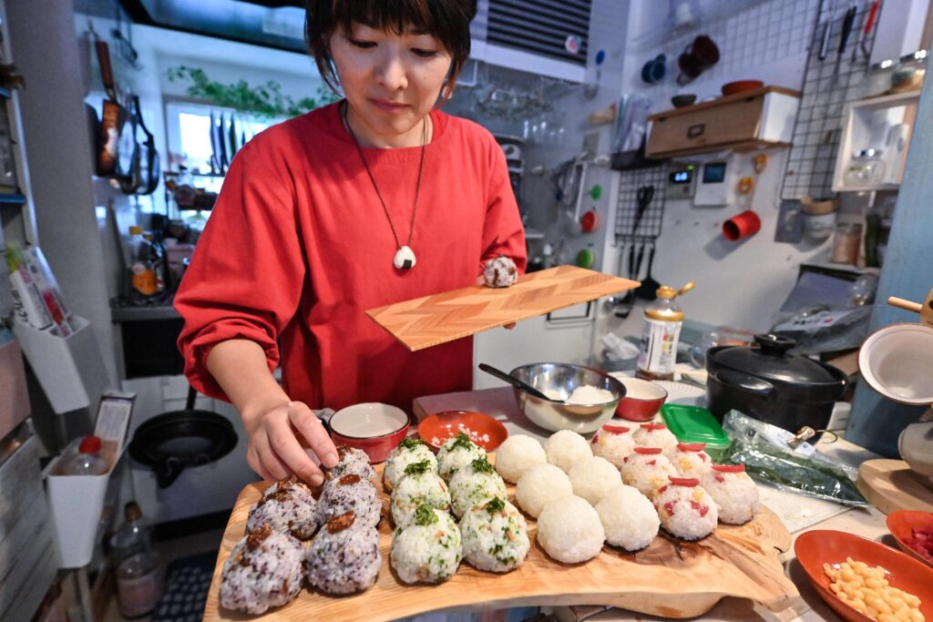 東京都内の自宅でおむすびを作る、おむすびケータリングサービス「笑むすび∞」経営の山田みきさん。2023年12月7日撮影。（AFP）