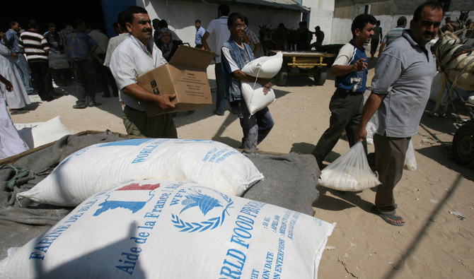 ガザ地区南部のラファで、UNRWAから受け取った食糧を運ぶパレスチナ難民。（AFP）