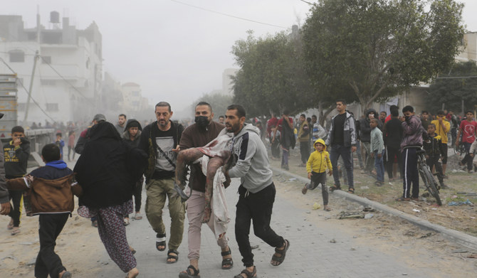 ガザ地区のラファで、イスラエルによる爆撃の生存者を避難させるパレスチナの人たち。（AP file photo）