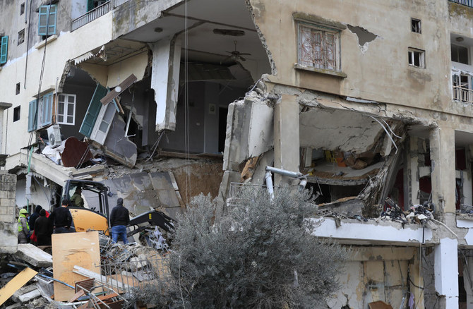 14日夜、レバノン南部の街ナバティエで、イスラエルの空爆を受けた建物からがれきを撤去する民間防衛隊員と救助隊員（AP）