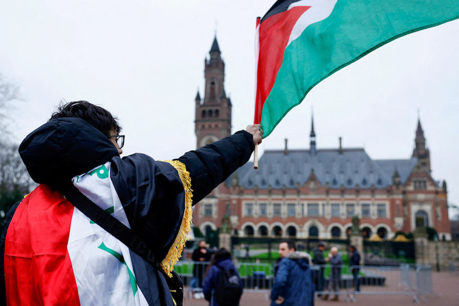 2024年2月21日、オランダのハーグで国際司法裁判所が審理を続ける中、パレスチナ国旗を振るデモ参加者。(ロイター）