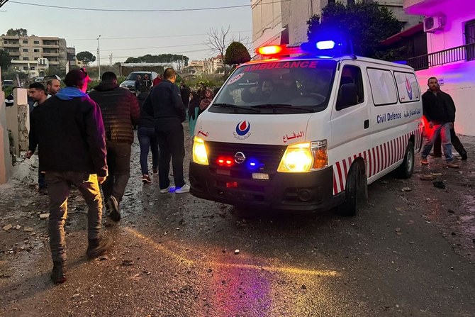 レバノン南部の町ナバティエ近郊のクファルルマンで、建物を狙ったイスラエルのドローンからの誘導ミサイル2発の攻撃を受けた現場に救急車が到着し、人々が集まる様子（AFP）